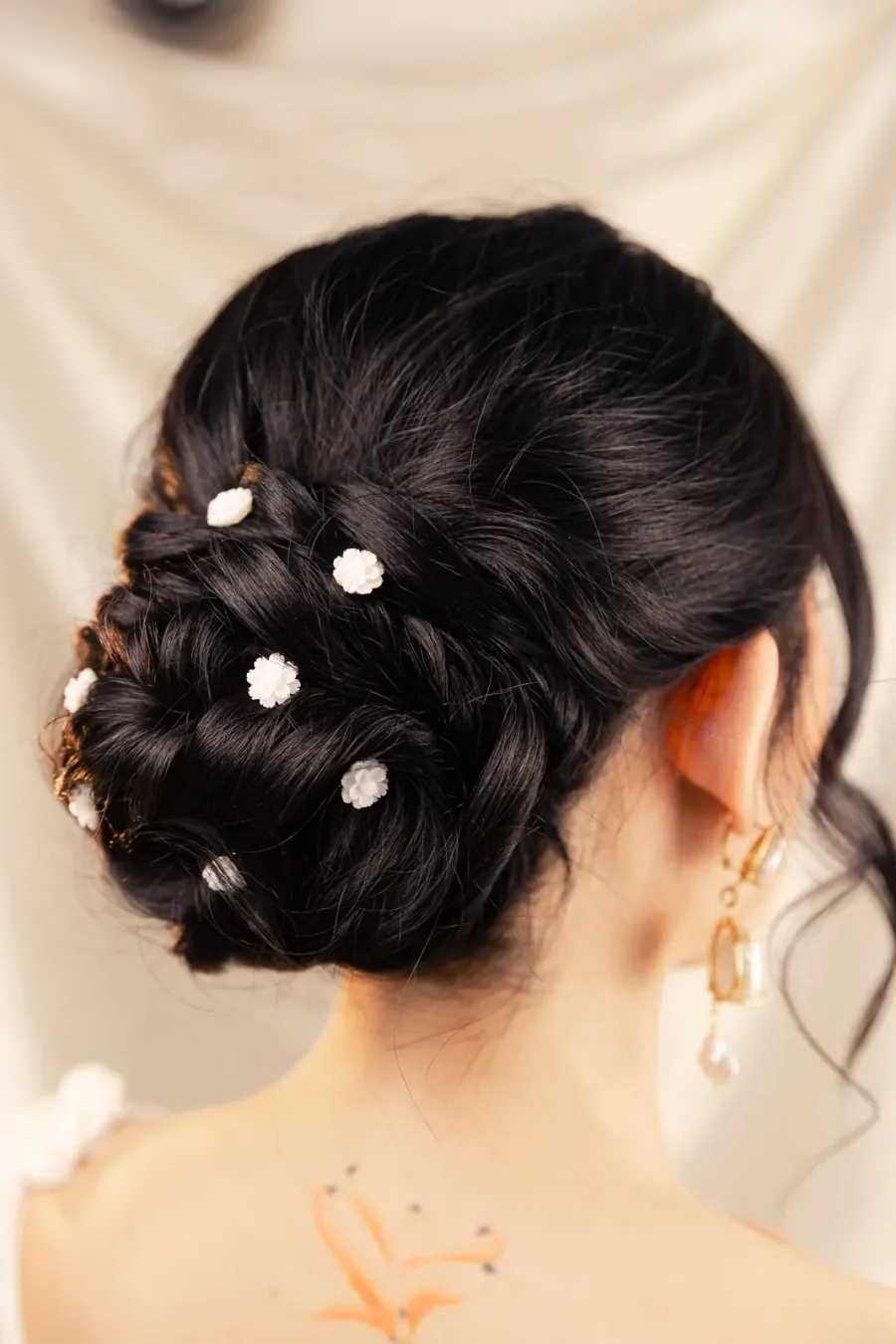 Updo with small white flowers, seen from behind