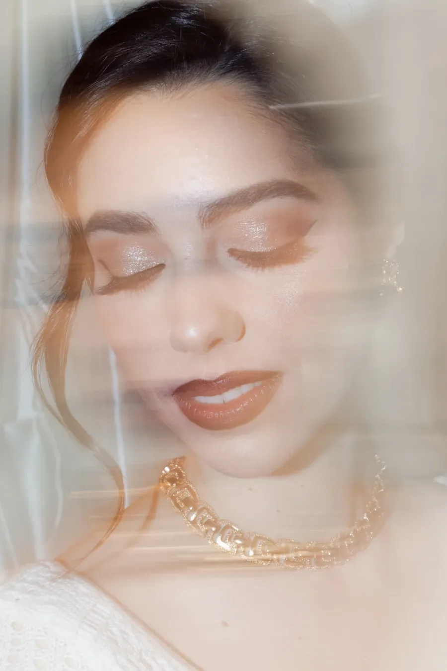 Portrait in motion, eyes closed, gold chain necklace
